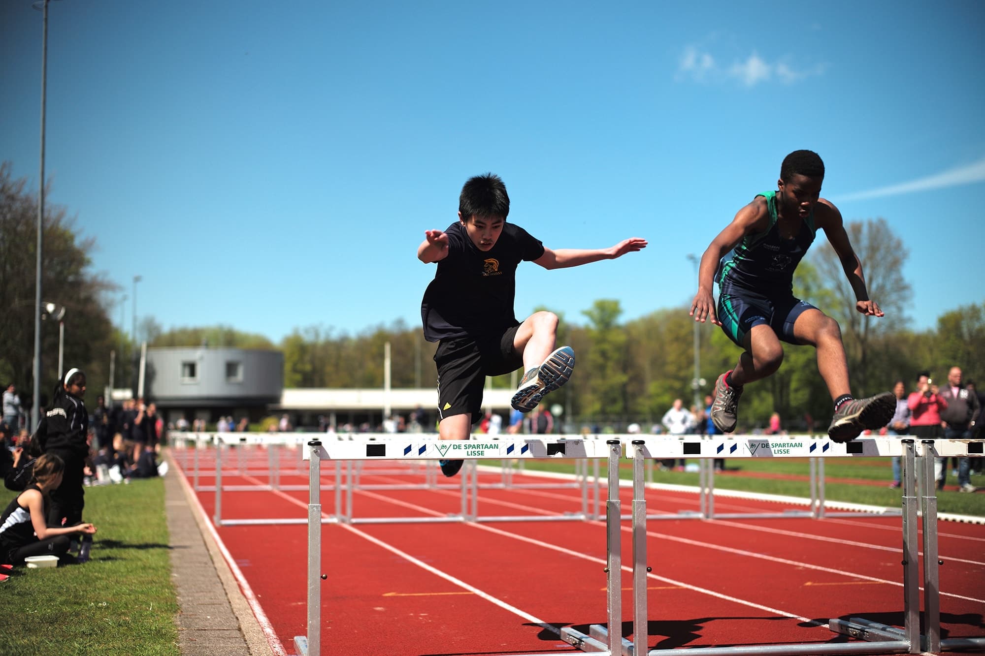 Children hurdling on a track.